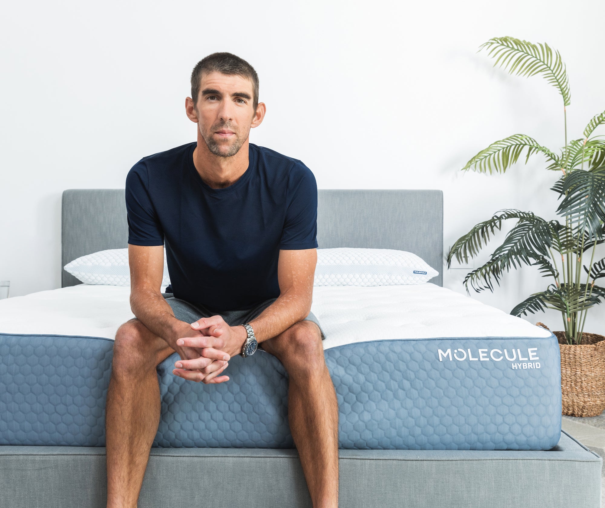 Michael Phelps sitting on a Molecule mattress with his hands clasped